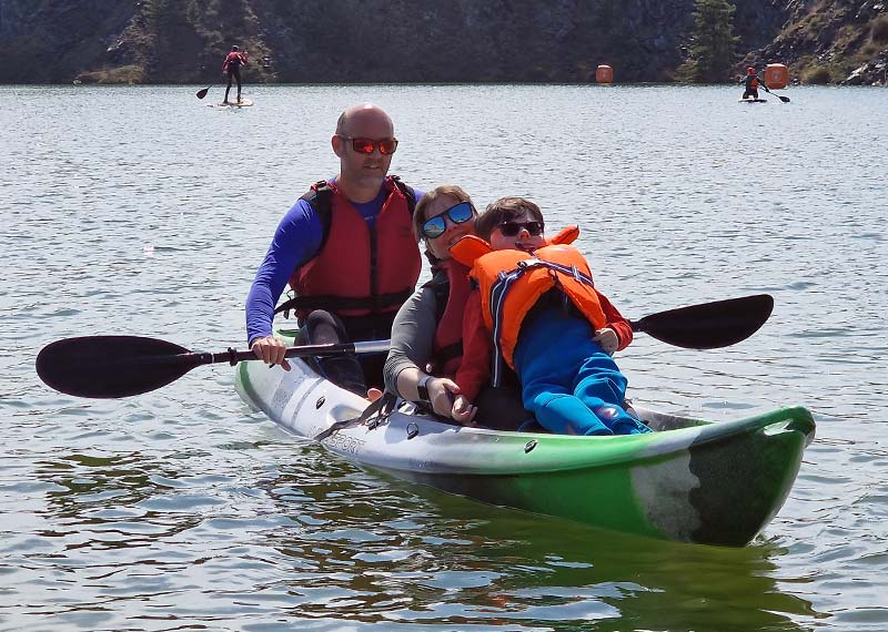 Family with disabled child using accessible kayak with Children's Sailing Trust Experiences