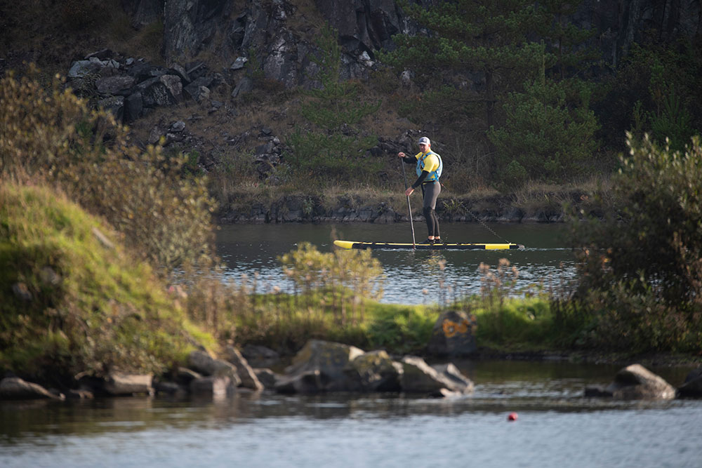 A man stands on a paddleboard on Trevassack Lake