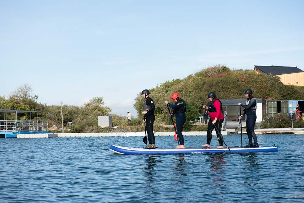 paddleboarding together on a team building day with CST Experiences