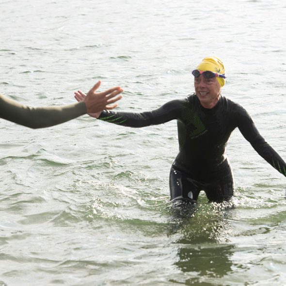 A swimmer being helped out of the water at Trevassack Lake - CST Experiences