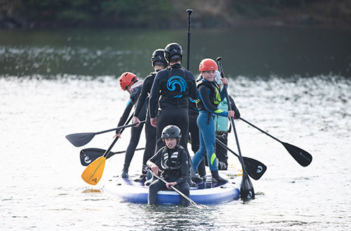 teenagers on a mega sup watersports with CST Experiences